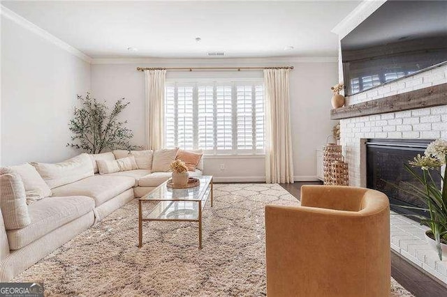 living room with crown molding, visible vents, wood finished floors, a fireplace, and baseboards