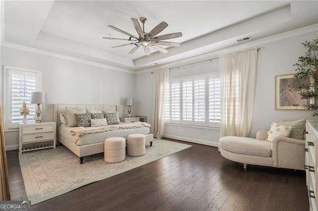 bedroom with baseboards, a ceiling fan, a tray ceiling, and hardwood / wood-style flooring