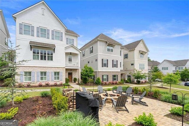 back of house with an outdoor fire pit and a patio area