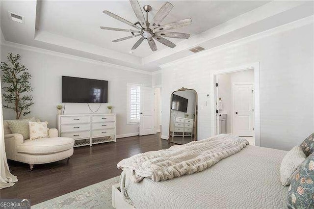 bedroom featuring a raised ceiling, a ceiling fan, wood finished floors, and visible vents