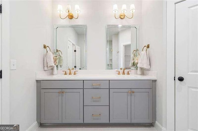 bathroom with a sink, baseboards, and double vanity