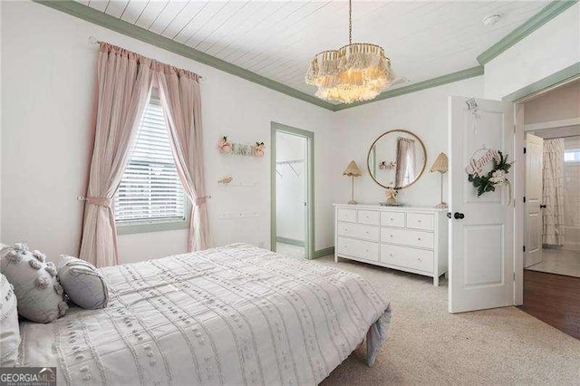 carpeted bedroom with baseboards, ornamental molding, and a notable chandelier