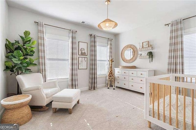 bedroom featuring a crib, baseboards, and visible vents