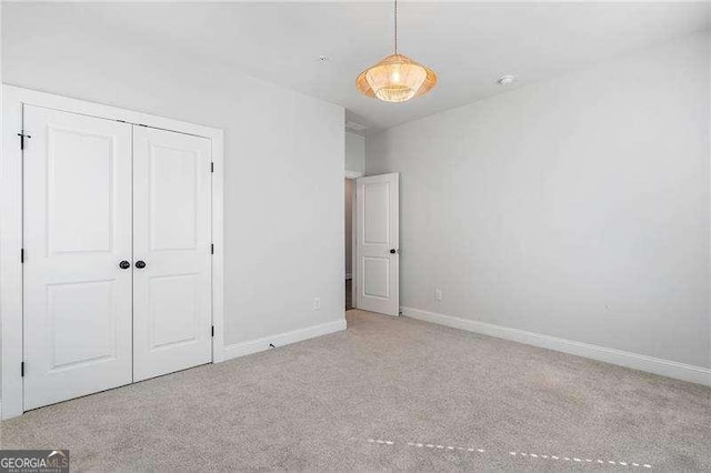 unfurnished bedroom with carpet floors, baseboards, and a closet