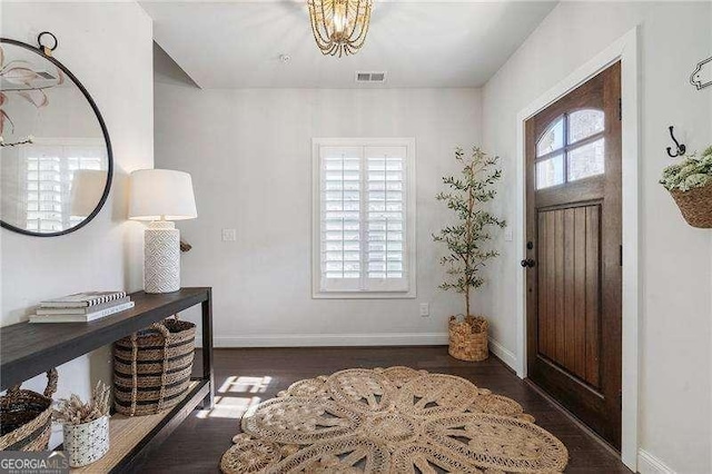 entryway with visible vents, baseboards, and wood finished floors