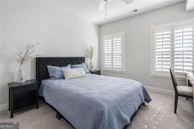 carpeted bedroom with baseboards, ceiling fan, and visible vents