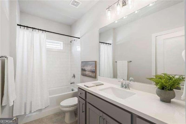 bathroom with vanity, shower / bath combo, toilet, and visible vents