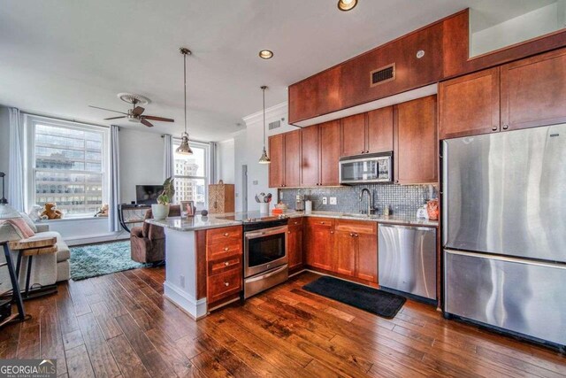 kitchen featuring appliances with stainless steel finishes, a sink, a peninsula, a ceiling fan, and visible vents