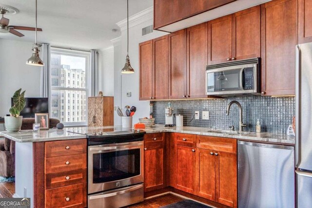 kitchen with a sink, a peninsula, a ceiling fan, appliances with stainless steel finishes, and backsplash
