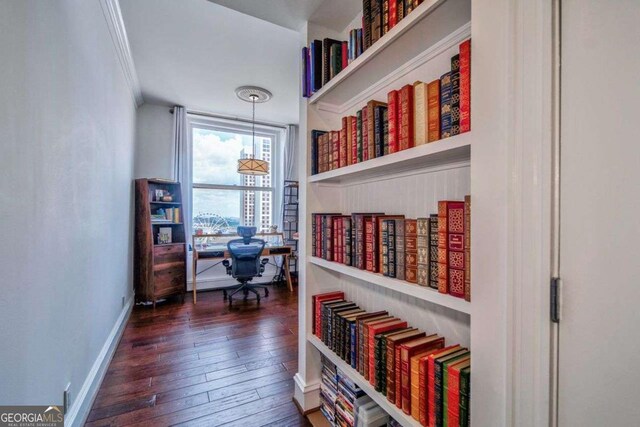interior space featuring crown molding, baseboards, and hardwood / wood-style flooring