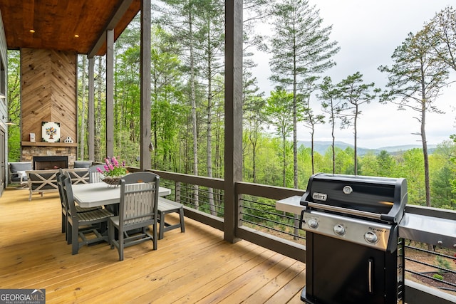 454 N Old Aska Rd, Blue Ridge, GA 30513 - wooden terrace with a stone fireplace, a grill, and outdoor dining area