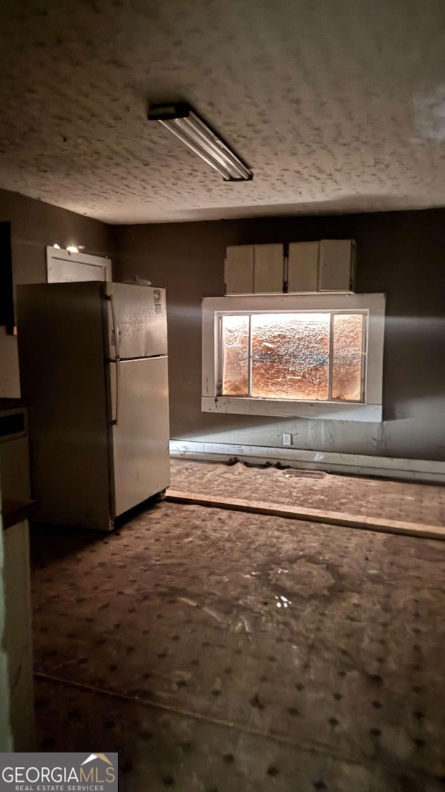 700 W College St, Bowdon, GA 30108 - kitchen featuring freestanding refrigerator and a textured ceiling