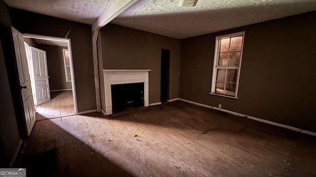 700 W College St, Bowdon, GA 30108 - unfurnished living room with baseboards, hardwood / wood-style floors, and a fireplace