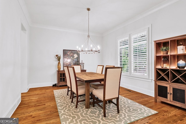 2201 Old Dallas Rd SW, Marietta, GA 30064 - dining space with wood finished floors, baseboards, ornamental molding, and a notable chandelier