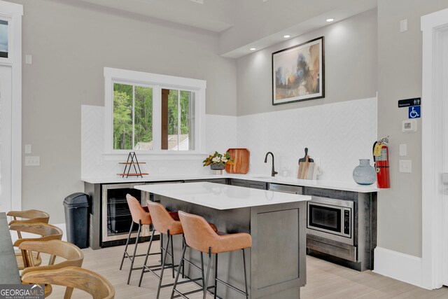 2201 Old Dallas Rd SW, Marietta, GA 30064 - bar featuring a sink, wine cooler, stainless steel microwave, and light wood-style floors