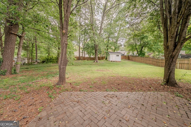 228 Amour Way SW, Lilburn, GA 30047 - view of yard featuring a storage unit, a patio area, a fenced backyard, and an outdoor structure
