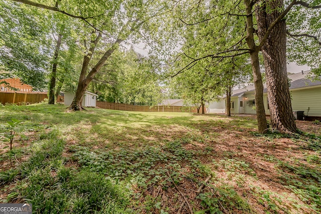 228 Amour Way SW, Lilburn, GA 30047 - view of yard featuring a storage unit, fence, central AC, and an outbuilding
