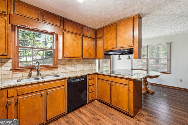 1366 Maple Ridge Dr, Suwanee, GA 30024 - kitchen with brown cabinetry, decorative backsplash, under cabinet range hood, a sink, and black appliances