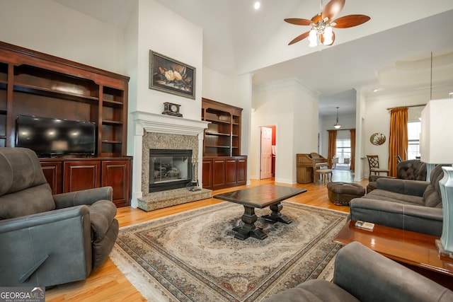 229 Deer Haven Run, Carlton, GA 30627 - living room with crown molding, ceiling fan, light wood-type flooring, lofted ceiling, and a high end fireplace