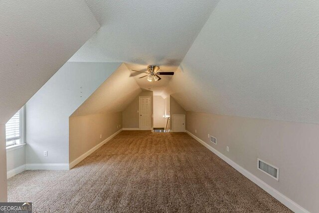 bonus room featuring a ceiling fan, a textured ceiling, and visible vents