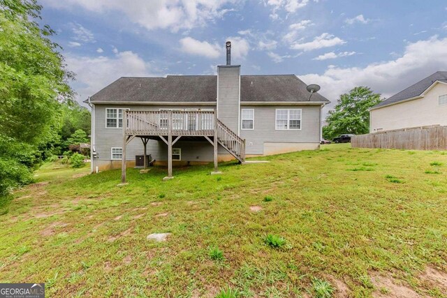 back of house with a wooden deck, fence, a chimney, stairs, and a yard