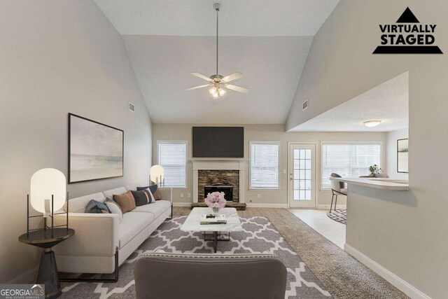 carpeted living room featuring a ceiling fan, visible vents, a fireplace, baseboards, and high vaulted ceiling