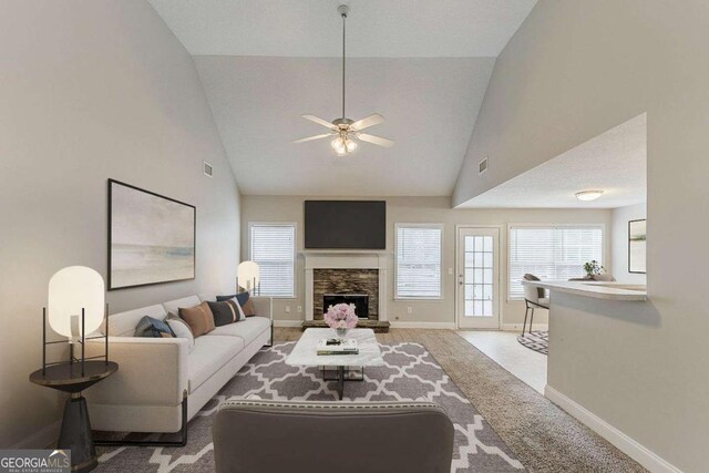 carpeted living room featuring ceiling fan, high vaulted ceiling, a stone fireplace, baseboards, and visible vents