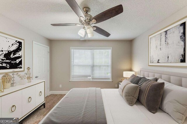 bedroom featuring carpet floors, a ceiling fan, a textured ceiling, and baseboards