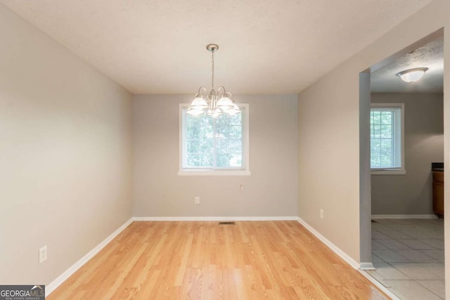 1051 S Millard Way, Stone Mountain, GA 30088 - unfurnished dining area featuring light wood-style floors and a chandelier