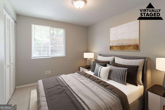 carpeted bedroom featuring baseboards and a closet