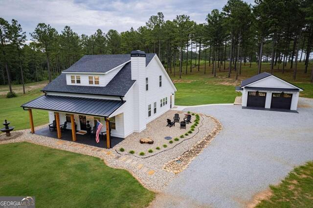 211 Hogan Coweta Rd, Hogansville, GA 30230 - view of home's exterior with a lawn, a chimney, an outdoor structure, and a detached garage