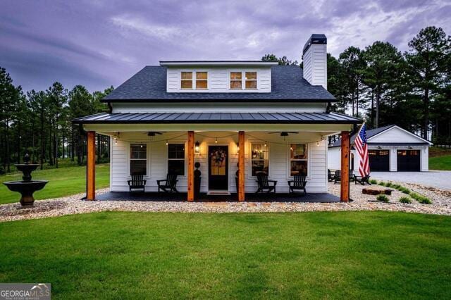 211 Hogan Coweta Rd, Hogansville, GA 30230 - view of front of house with covered porch, a standing seam roof, a chimney, a garage, and a front lawn