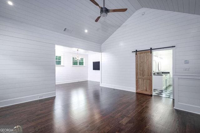 211 Hogan Coweta Rd, Hogansville, GA 30230 - empty room featuring a barn door, high vaulted ceiling, ceiling fan with notable chandelier, baseboards, and wood finished floors