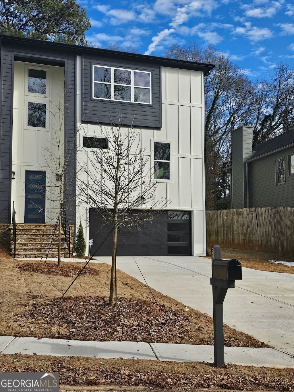 503 Glendale Rd Unit 0, Scottdale, GA 30079 - view of front of home with concrete driveway, an attached garage, and board and batten siding