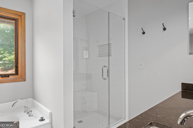 full bathroom featuring a stall shower, a garden tub, and a sink
