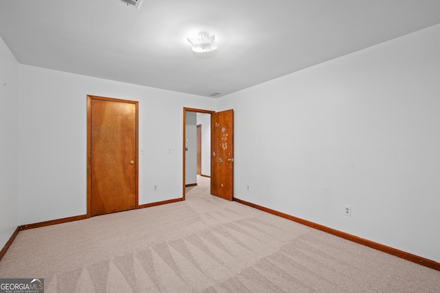 unfurnished bedroom with light carpet and baseboards