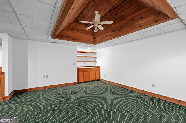 carpeted empty room with baseboards, a ceiling fan, and a paneled ceiling