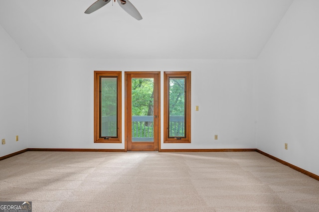 spare room with carpet flooring, vaulted ceiling, baseboards, and a ceiling fan