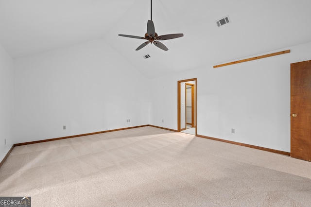 spare room featuring a ceiling fan, visible vents, baseboards, light carpet, and lofted ceiling