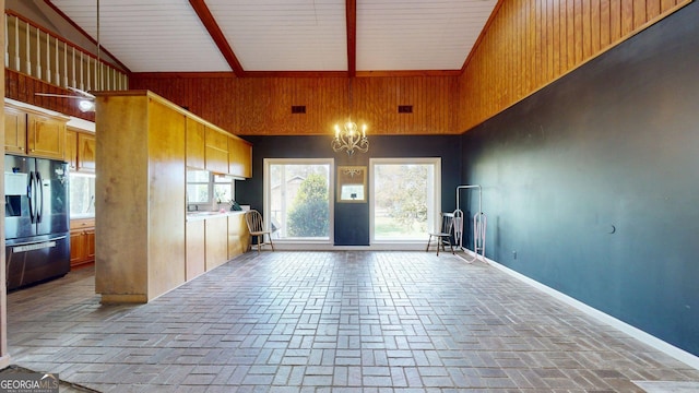 1717 Grady Saunders Rd, Portal, GA 30450 - interior space featuring a notable chandelier, brick floor, high vaulted ceiling, wood walls, and stainless steel refrigerator with ice dispenser