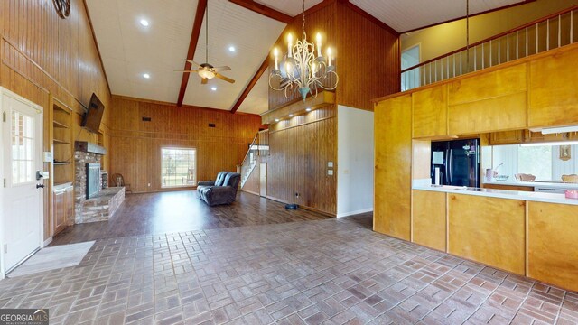 1717 Grady Saunders Rd, Portal, GA 30450 - kitchen featuring wooden walls, black fridge, brick floor, high vaulted ceiling, and open floor plan