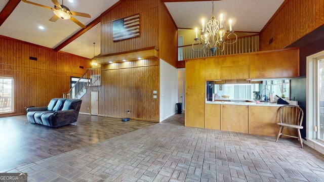 1717 Grady Saunders Rd, Portal, GA 30450 - kitchen featuring open floor plan, wooden walls, high vaulted ceiling, brick floor, and ceiling fan with notable chandelier