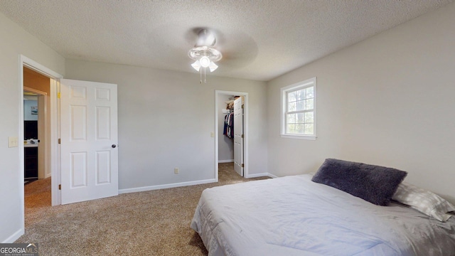 1717 Grady Saunders Rd, Portal, GA 30450 - carpeted bedroom featuring baseboards, a ceiling fan, a textured ceiling, and a walk in closet