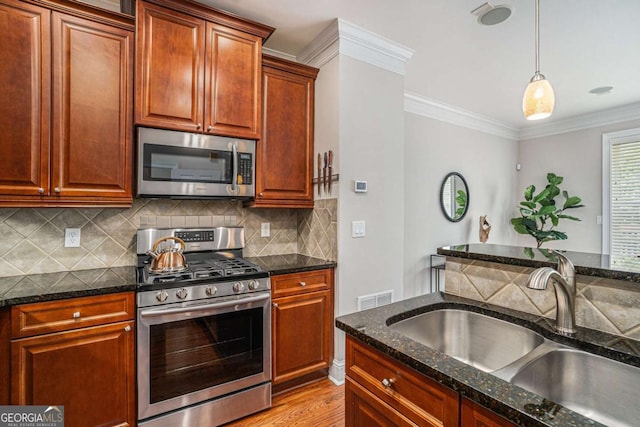 75 High Top Ln, Sandy Springs, GA 30328 - kitchen featuring appliances with stainless steel finishes, decorative light fixtures, decorative backsplash, dark stone countertops, and light wood-style flooring