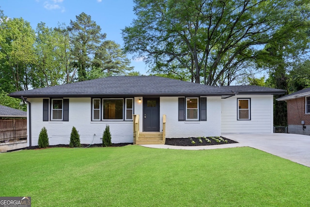 ranch-style house featuring fence, a front lawn, and brick siding