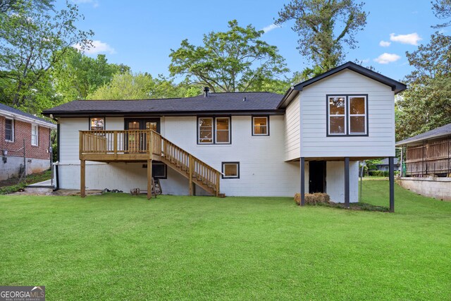 rear view of house featuring stairway, a yard, a wooden deck, and a shingled roof