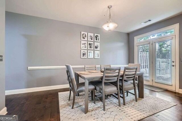 dining area with baseboards, hardwood / wood-style floors, and visible vents
