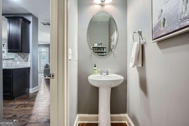 bathroom with wood-type flooring, baseboards, and visible vents