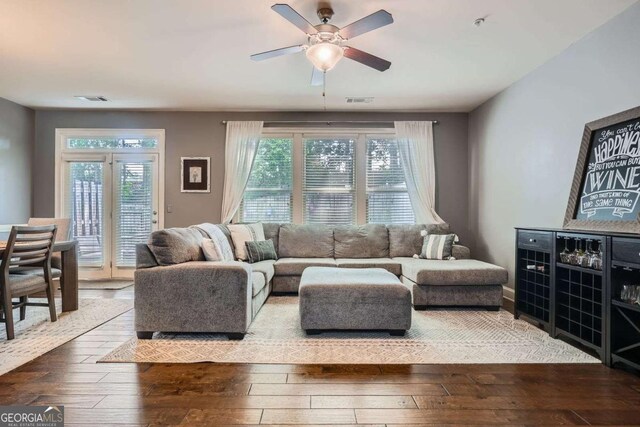 living room featuring visible vents, ceiling fan, a healthy amount of sunlight, and hardwood / wood-style flooring