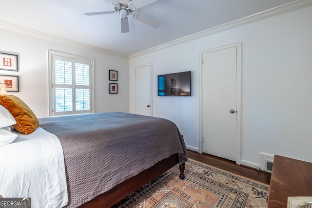 bedroom with crown molding, baseboards, ceiling fan, and wood finished floors
